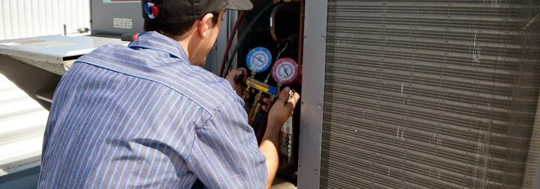 HVAC technician servicing a condenser unit in Roseville