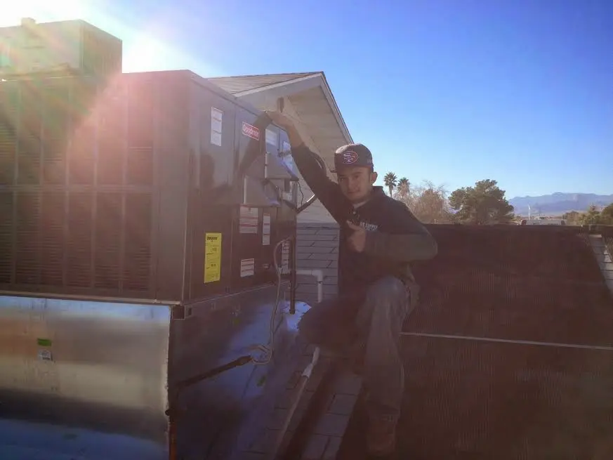 HVAC technician performing Air Duct Cleaning on a rooftop unit in Roseville